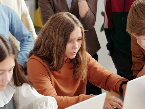 Aluna olha atentamente para o computador enquanto resolve uma etapa do desafio de programação