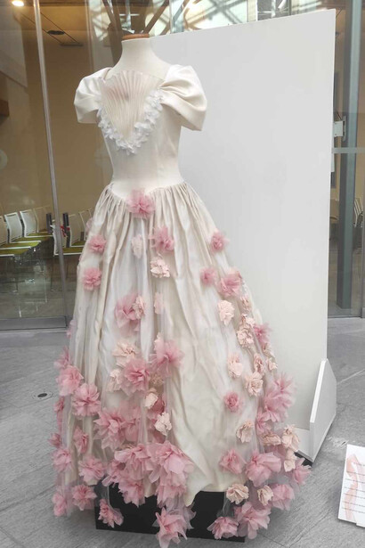 Un abito da sposa ricoperto di fiori rosa a simboleggiare purezza e innocenza