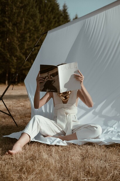 A person holding a magazine in front of their face. What one sees is what one sees when one perceives what is evidenced