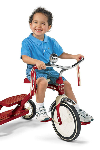 Niño pequeño en su primer triciclo