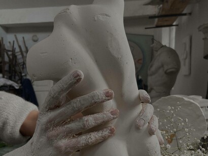 A person sculpting a bust made out of clay