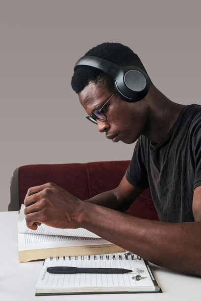 Estudiante leyendo y tomando notas mientras oye música