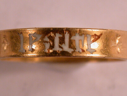 Anillo de oro con una inscripción en francés grabada alrededor del exterior del aro en escritura gótica o en letras negras, que dice + tout + dis + en + lealte