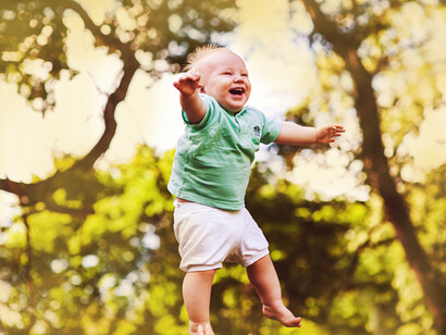 A baby jumps with joy