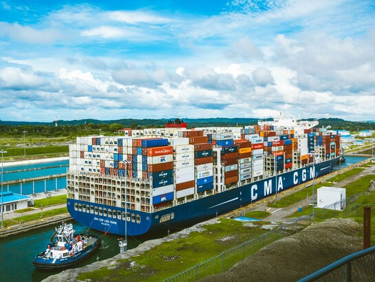 A vast cargo ship passing through the Panama Canal, representing the strategic importance of maritime trade and regional waterways