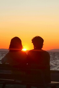 Casal assiste o atardecer juntos