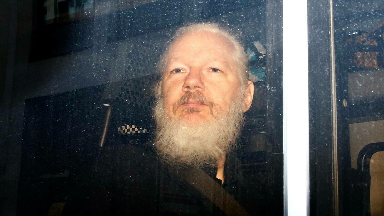 Assange a bordo del furgone della polizia durante l'arresto