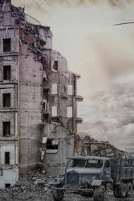 Ruins of a war-torn area, with military helicopter flying overhead