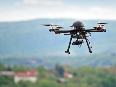 A black drone parked in mid-air