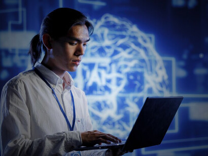 An IT specialist in an office apartment leverages programming skills to enhance AI technology