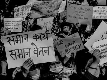 A black-and-white photograph of women protesting with banners, reflecting activism, advocacy, and collective action