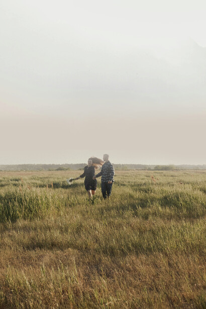 Una pareja corriendo por el campo junta