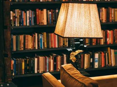 Lámpara de mesa ubicada cerca de estantes con libros