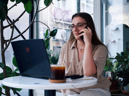 Young woman working on a laptop at a café table