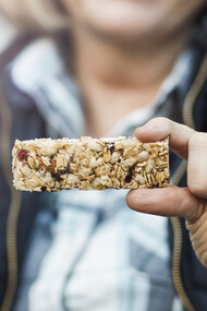 A woman’s hands holding a protein bar