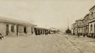 Composición fotográfica elaborada a partir de la fusión de tres imágenes antiguas de Cartago, tomadas antes del terremoto de 1910. La fotografía de la izquierda, capturada por Philip y Amelia Calvert, muestra la casa tradicional de Anacleta, cuando albergaba la tienda El Irazú de don Felipe Martín en 1910. Las otras dos, de autor desconocido, corresponden a la Escuela de Párvulos y al hotel Estrella del Norte (a la derecha). Fusión fotográfica realizada por Florentino Leiva Ortega, 2025