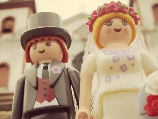 Um casal de Playmobil posa diante de uma igreja em uma cena de casamento criada e fotografada por Maria Moysés. Transformando pequenos bonecos em protagonistas de grandes histórias, o projeto iloveplaymo mostra como imaginação e memória afetiva podem dar novos significados à infância