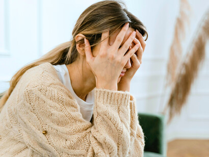 A lady holding her head in her hand as she feels the stress which often builds up as time passes by until reaching a breaking point