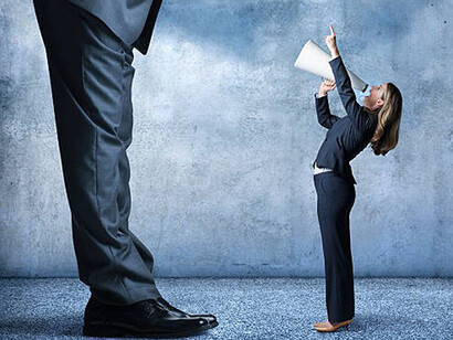Businesswoman shouts through megaphone towards much larger businessman