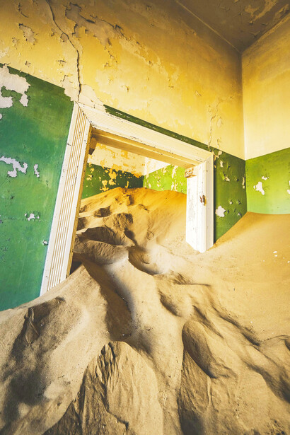 A doorway half-swallowed by sand, Kolmanskop, Namibia, photographed by Francesco Ungaro