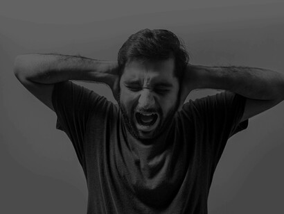 A young man yelling and trying to shed the stresses that he has been experiencing 