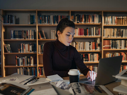 A brunette woman working late at night in her home office