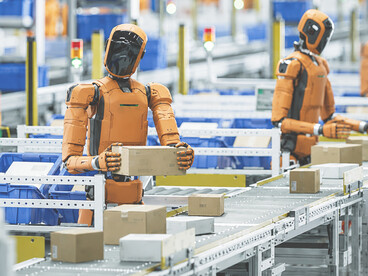 General-purpose humanoid robots working in a fulfillment center, efficiently sorting parcels and transporting packages within a high-tech logistics environment