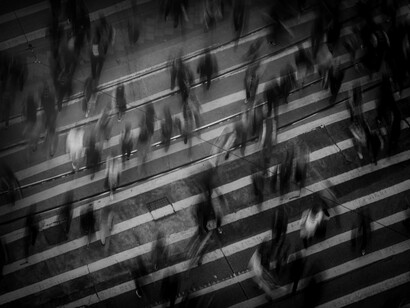 Gente camina rápidamente sobre un pase peatonal hacia sus destinos