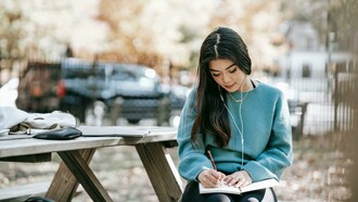 Adolescente con le cuffie scrive sul diario. Il viaggio della lettura: una ragazza tra le pagine e le strade affollate della vita