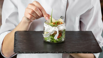 A chef presenting an enticing dish, showcasing current culinary trends