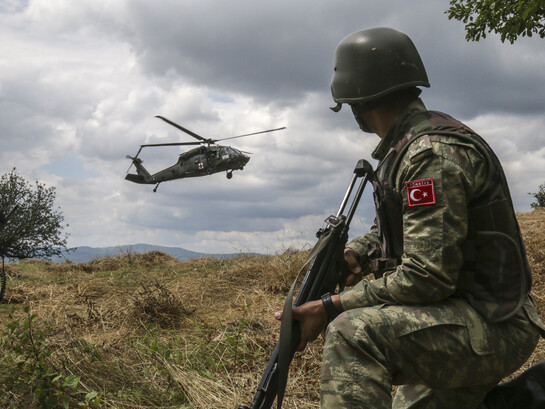 A Turkish soldier, with Multinational Battle Group-East, watches as a UH-60 Black Hawk gets ready to land after receiving a 9-line call for a simulated casualty. U.S. and NATO forces have contributed to the United Nations-mandated peacekeeping mission in Kosovo since June 1999