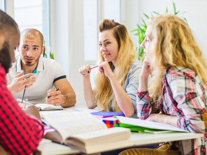 Young students studying together at one table during a group discussion