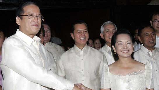 Benigno Simeon Aquino III, the 15th President of the Philippines who served from 2010 to 2016, dons a Barong Tagolog while shaking hands with Gloria Macaraeg Macapagal-Arroyo, the 14th President of the Philippines who served from 2001 to 2010, at Aquino's inauguration at the Malacañang Palace, in Manila, Philippines, on the 30th of June, 2010