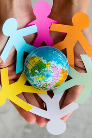 A top-view image of interconnected origami people forming a chain around the globe, symbolizing unity, peace, and vibrant diversity with an array of colors