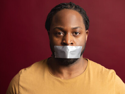 A man with his mouth covered by tape. Self-censorship is making us stuck into the vicious cycle of pleasing others, rather than expressing our ideas and thoughts