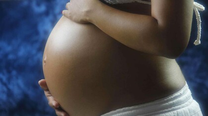 A pregnant black woman taking ownership of her womb