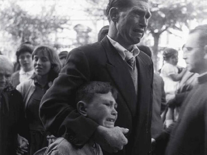 Un padre y su hijo entre un grupo de emigrantes