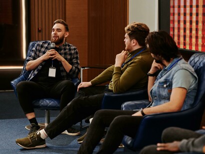 A group participates in an innovation conference panel, sharing ideas and insights
