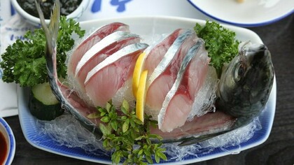 A platter of gleaming raw mackerel sashimi artfully arranged with head and tail intact, showcasing Jeju’s devotion to “hwe” and the island’s celebration of the freshest catch