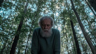 An ageing man in the forest trying to catch his breath