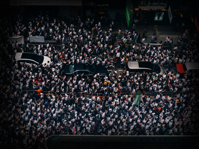 Automóviles intentan abrirse paso entre la multitud en las calles de Hong Kong, China