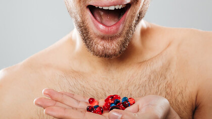 Cropped image of a happy man taking multivitamin supplements