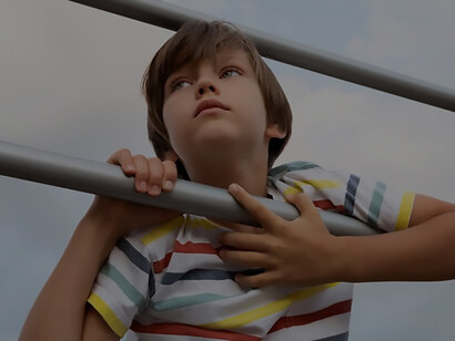 Emotive storytelling with a medium shot featuring a contemplative boy on a bench, lost in wistful daydreams of youth