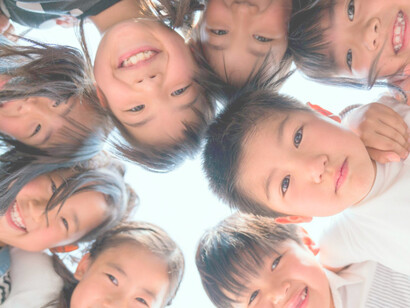 Niños fotografiados con sus cabezas juntas y sonriendo