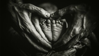 As mãos de dois adultos envolvem os pés de um bebê em formato de coração, simbolizando proteção, cuidado e a continuidade dos laços familiares. O artigo defende que a família deve permanecer como a principal fonte de orientação para as novas gerações. A transmissão de ensinamentos entre gerações é apontada como um dos pilares para a construção de lares duradouros. A transmissão de ensinamentos entre gerações é apontada como um dos pilares para a construção de lares duradouros