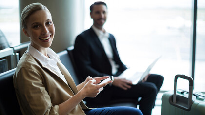 Smiling commuters sitting in an airport waiting area