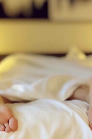 Person laying on their stomach asleep in bed