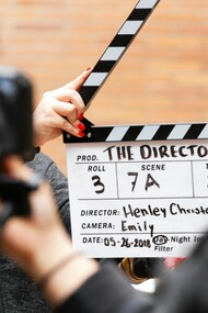 A man holding a clapperboard, symbolizing Russian cinema's growing presence in Hollywood