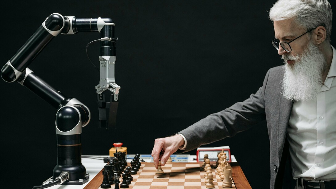 Un homme joue aux échecs avec une machine représentant une lutte entre l'intelligence humaine et l'intelligence artificielle