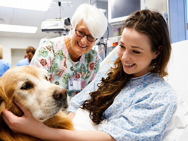 Therapy dog providing emotional support to a young female patient recovering in hospital